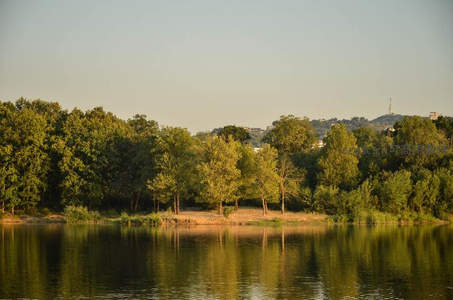 绿荫湖岸映晴空，远山微露城市影