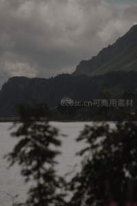 阴云笼罩山间湖畔孤屋隐现