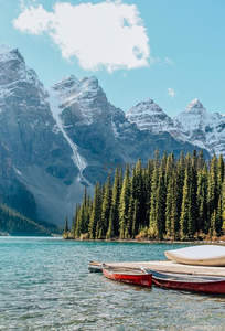 雪山环抱碧湖畔，独木舟静候探险