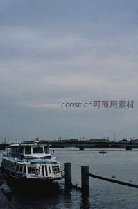 河畔停泊的渡轮与远处桥梁