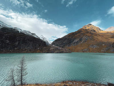 碧蓝高山湖泊静卧，雪峰环抱秋色斑斓
