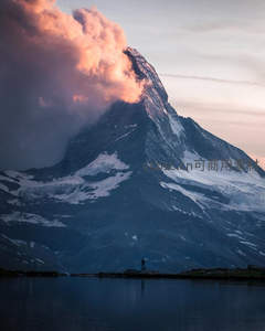 雪山之巅云霞映照，湖畔孤影仰望壮丽