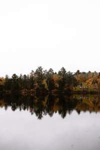 秋日湖畔层林尽染，水面倒影如镜