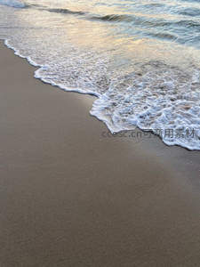 夕阳余晖洒在沙滩，海浪轻吻海岸线