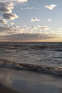 夕阳海浪轻拍沙滩，云霞映照天际线