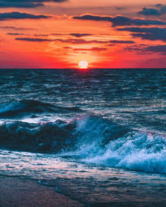 落日熔金，海面波涛映红霞，壮美无垠