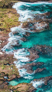 碧绿海水拍打礁石的航拍视角