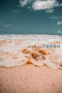 泡沫轻吻沙滩，微距视角下的海边温柔瞬间