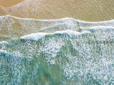 俯视镜头捕捉海浪轻抚沙滩