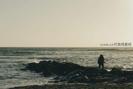 海边岩石上孤独的身影凝望远方海平线
