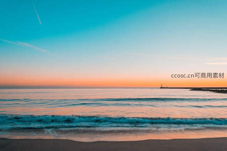 日落时分的宁静海岸线与远方灯塔