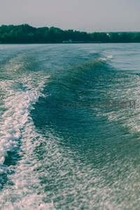 快艇驶过水面留下的蜿蜒白色水痕