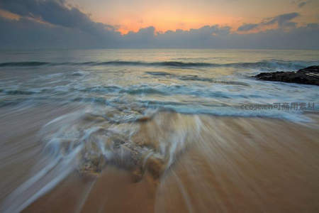 夕阳下流动的海浪与沙滩