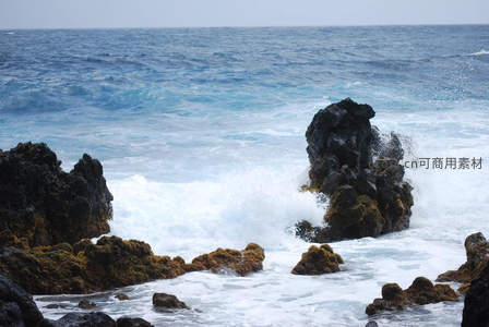 海浪拍打礁石激起白色浪花