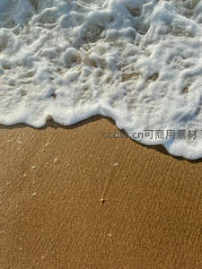 泡沫轻吻金色沙滩的瞬间