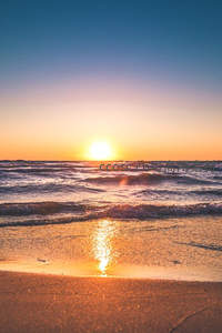 金色夕阳洒满海岸，波光粼粼如梦似幻