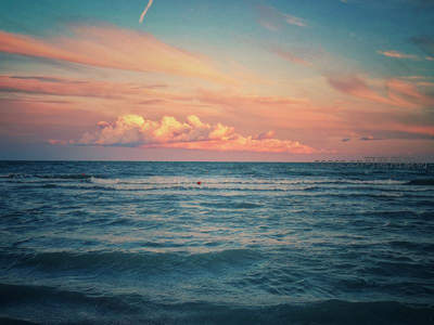 粉紫霞光染云海，平静海面泛涟漪