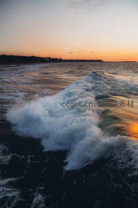 夕阳余晖洒满翻腾海浪的壮阔瞬间