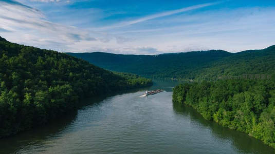 碧水青山间，货船悠然驶过峡谷河道