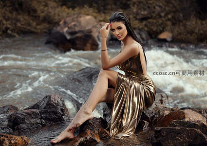 溪边岩石上金衣美人轻抚额发回眸