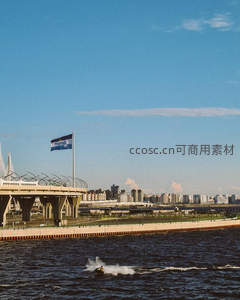 河面摩托疾驰，城市天际线与飘扬旗帜相映成趣