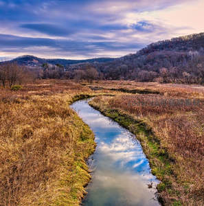 蜿蜒溪流穿行秋野，倒影如镜