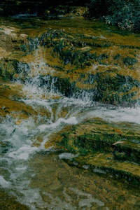 层叠瀑布冲刷青苔覆盖岩壁