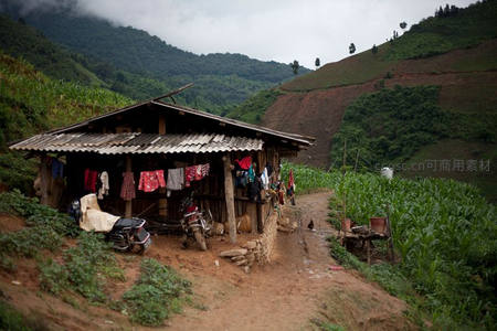 山间农舍旁晾晒衣物与玉米田