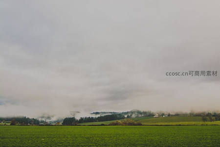 云雾缭绕的绿色田野与远山