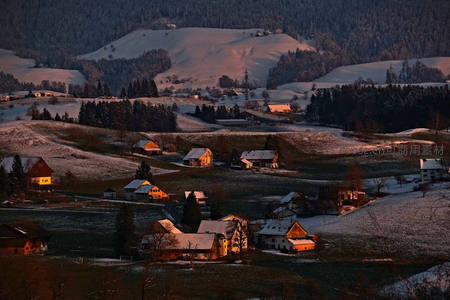 雪覆山谷中温暖灯火的村庄