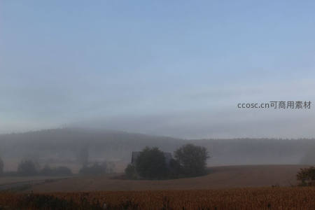 薄雾笼罩乡野间，孤屋静立如仙境