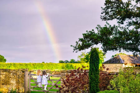 双童倚门观彩虹，石墙花园映田园诗意