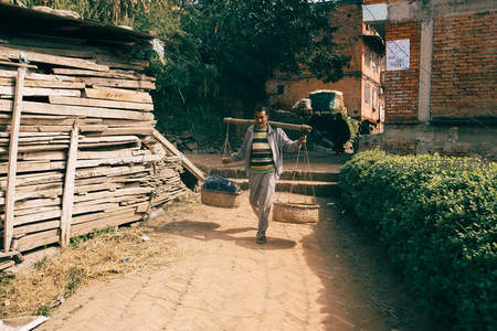 挑担行于村道归家路