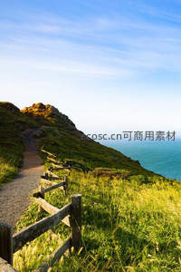 海岸悬崖小径，阳光洒满绿野与蔚蓝大海