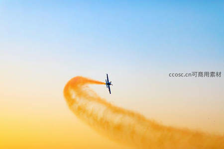 特技飞机划破天际留下橙色烟雾轨迹