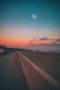 月圆之夜海滩步道旁晚霞绚烂