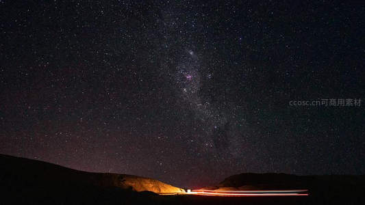 银河横贯夜空，车轨划破寂静山野