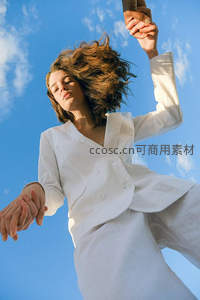 白衣女子凌空跃起，蓝天为幕展自由