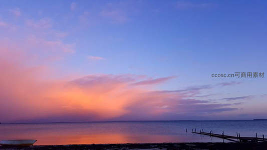 湖面倒映晚霞，小舟静泊码头边
