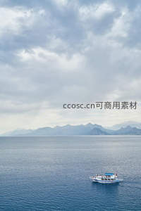 游轮驶过云影下的宁静海湾