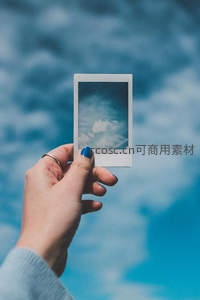 手持拍立得定格天空云朵