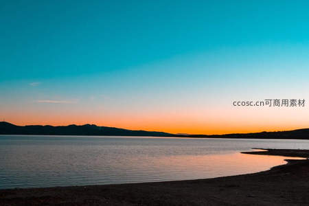 湖畔日落余晖倒映山峦剪影