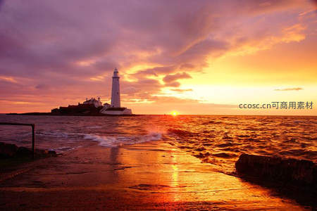 灯塔守望海岸线，夕阳熔金映海波