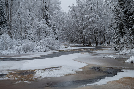 雪林溪流蜿蜒，远人点缀其间