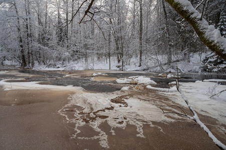 雪覆林间溪流，冰水交融静谧景