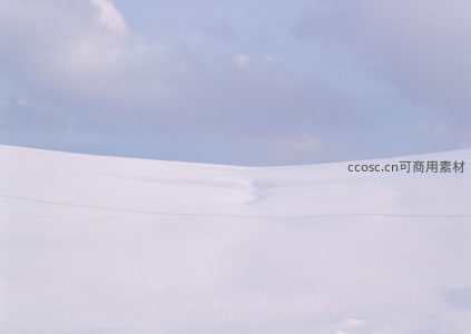雪丘柔美曲线映衬淡蓝天空，静谧如画