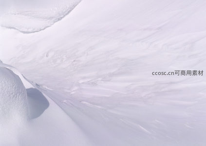 航拍视角下的雪原波浪纹路，如诗如画