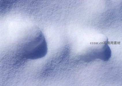 阳光下雪地上的两个圆润雪堆，可爱如小精灵