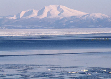 雪山脚下冰封湖面，静谧如画