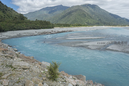 河畔碎石生野草，远山苍翠接云天